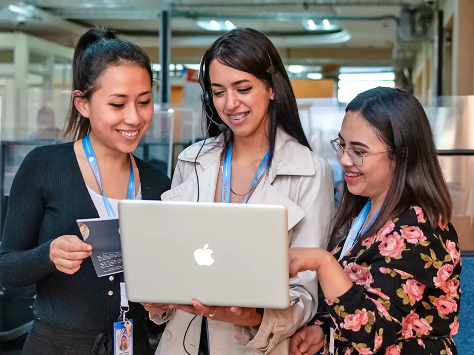 Three 14 Degrees team members reviewing results together on a laptop
